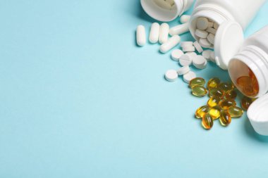 Mavi arka planda plastik şişelerde farklı haplar. Tıp konsepti. Boşluğu kopyala