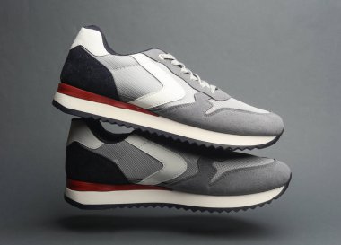 Koyu gri arka planda yüzen spor ayakkabıları.