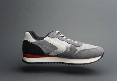 Koyu gri arka planda yüzen spor ayakkabı.