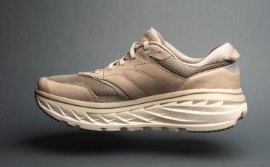 Koyu gri arka planda yüzen spor ayakkabı.