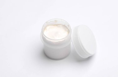 Beyaz arka planda bir kavanoz beyaz guaj boyası.