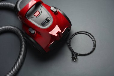 Koyu arkaplanda kırmızı elektrik süpürgesi. Üst görünüm