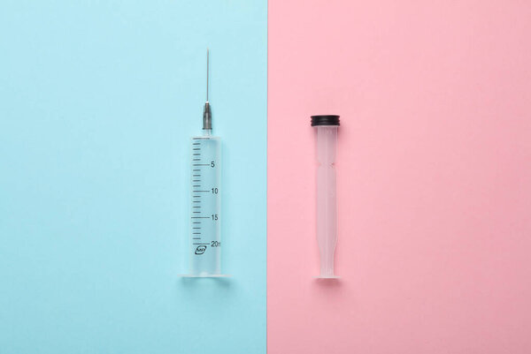 Syringe on a blue-pink background. Top view
