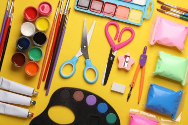 Sarı arka planda çocukların yaratıcılığı için çok farklı ürünler var.