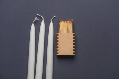 Karanlık arka planda kibritleri olan mumlar. Kesinti