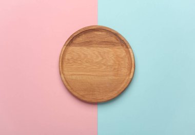 Mavi pastel arka planda ahşap bir tabak.