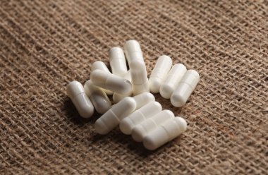 Çuval bezi üzerine beyaz haplar. Yakın plan.