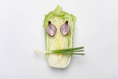 Beyaz arka planda yüz şeklinde sebzeler. Minimalizm kavramı. Sağlıklı beslenme, vegan.