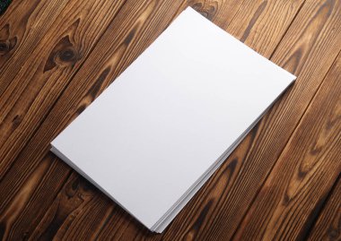 Tahta üzerinde beyaz, boş A4 kağıtları. Tasarım için model