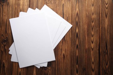 Tahta üzerinde beyaz, boş A4 kağıtları. Tasarım için model