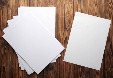 White blank sheets of A4 paper on wooden boards. Mockup for design