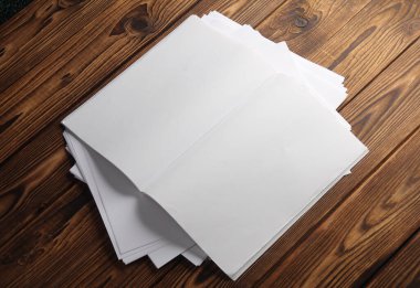 Tahta arka planda beyaz kağıtlı beyaz dergi veya not defterini aç