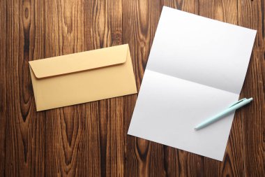 Tahta zemin üzerinde beyaz kağıt mektup ve zarf