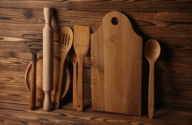 Tahtaların üzerinde ahşap mutfak aletleri var..