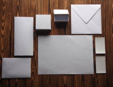 Beyaz boş kağıt, not defteri, kartvizit, zarf, tahta tahtadaki kutu. Tasarım şablonu. İş konsepti. Düz yatıyordu