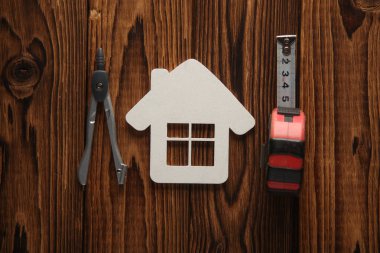 Mühendis aletleri ve ahşap tahtalarda ev modeli..