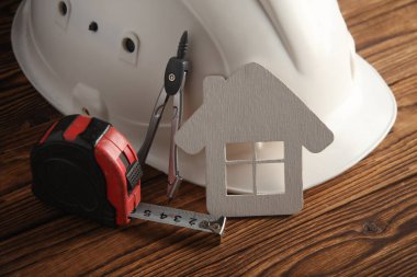 İnşaat aletleri ve ev modeli tahta tahtalarda..