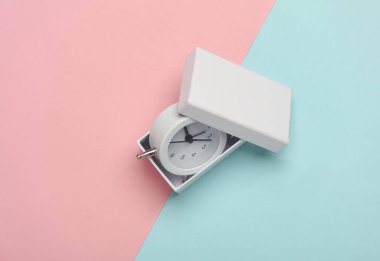 Mavi pembe arkaplanda alarm saati olan kutu