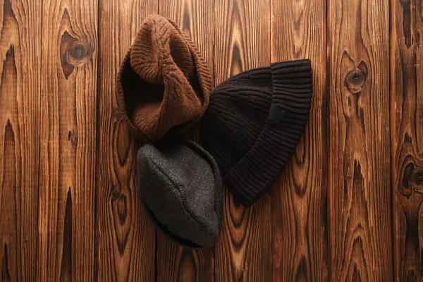 Various winter hats on a wooden background. Top view