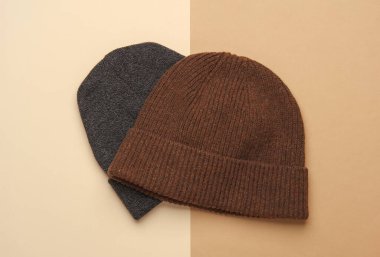 Bej kahverengi arka planda yünlü sıcak kış şapkaları.