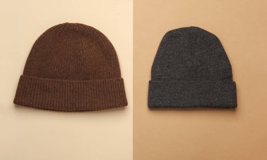 Bej kahverengi arka planda yünlü sıcak kış şapkaları.