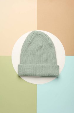 Nane yeşili. Pastel arka planda yünlü sıcak kış şapkası.