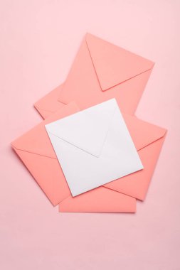 Kare kağıt pembe ve beyaz zarflar pembe arka planda
