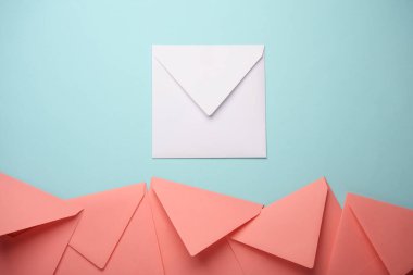 Mavi pastel arka planda pembe ve beyaz kağıt zarflar