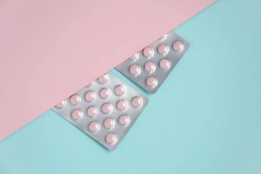 Pastel arka planda pembe tablet kabarcıkları. Tıp konsepti. Üst görünüm