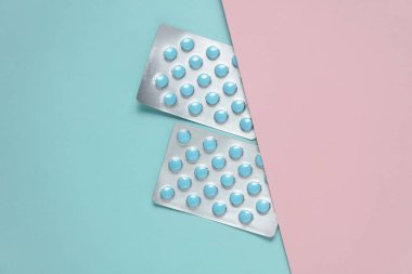 Pembe arkaplanda iki mavi tablet kabarcığı