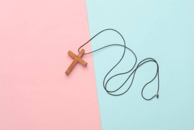 Ahşap bir Hıristiyan haçı, pembe mavi arka plan