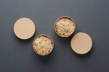 Yuvarlak, tek kullanımlık, arka planda yulaf ezmesi olan karton kutular. Sağlıklı fast food