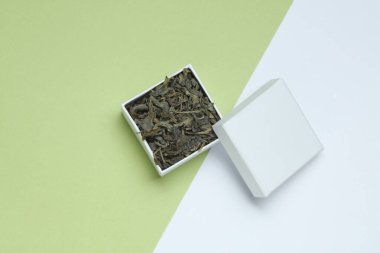 Pastel arka planda beyaz karton kutuda yeşil çay