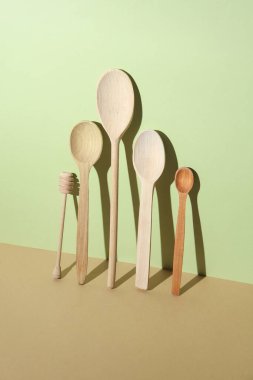 Renkli pastel arka planda, gölgeli tahta kaşıklar.