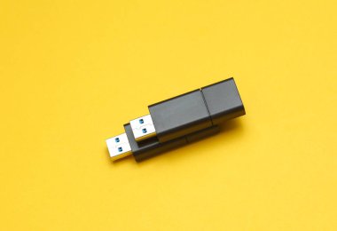 Sarı arka planda iki siyah USB flaş bellek