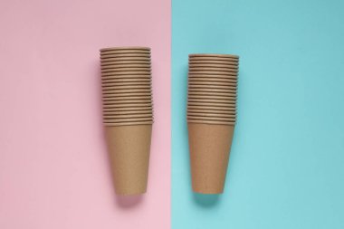 Mavi pembe arka planda tek kullanımlık bardaklar yığını