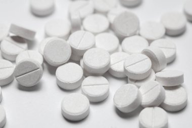 Beyaz arka planda beyaz hapların yakın plan çekimi. Tıp konsepti