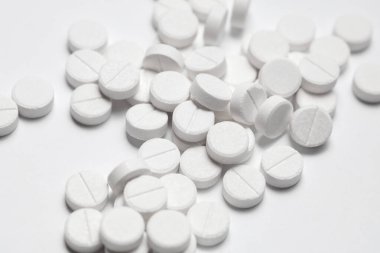 Beyaz arka planda beyaz hapların yakın plan çekimi. Tıp konsepti