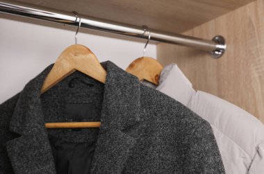 Erkeklerin paltoları askılarda asılı.