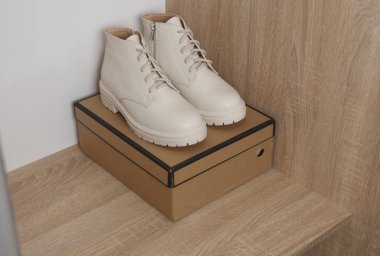 Dolapta kutu olan kadın beyaz deri çizmeleri.