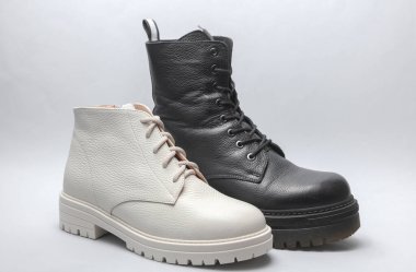 Beyaz arka planda kadın beyaz ve siyah deri çizmeleri.. 