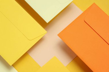 Sarı arka planda yüzen zarflar ve kartlar. Davetiyeler, şirket kimlikleri.