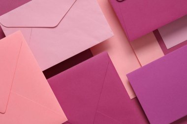 Pembe arka planda yüzen pembe tonlar zarflar ve kartlar. Davetiyeler, şirket kimlikleri.