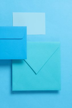 Mavi arka planda yüzen mavi tonlar zarf ve kartvizit seti. Davetiyeler, şirket kimlikleri.