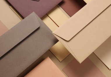 Bej arka planda yüzen zarflar ve kartlar. Davetiyeler, şirket kimlikleri. Yaratıcı yerleşim