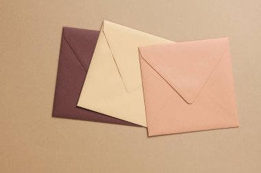 Bej arkaplanda zarflar. Davetiyeler, şirket kimlikleri. Yaratıcı yerleşim