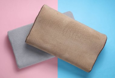 Mavi-pembe renkli arka planda ortopedik iki yastık. Sağlıklı ve rahat bir uyku.