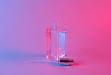 Mavi-pembe renkli neon ışıklı parfüm şişesi.