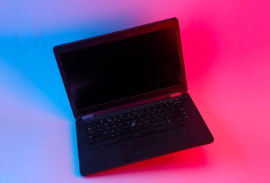 Mavi-pembe neon ışıkta süzülen modern dizüstü bilgisayar