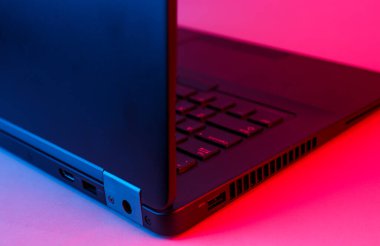Mavi-kırmızı renkli modern dizüstü bilgisayar, neon ışığı kapat.